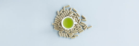 Cup of green tea surrounded by capsules symbolizing how long L-theanine lasts in the body and its absorption timeline.